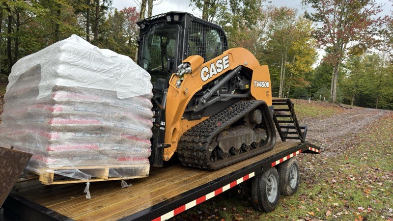 Skid steer loader performing finish grading on residential lot in Mexico NY